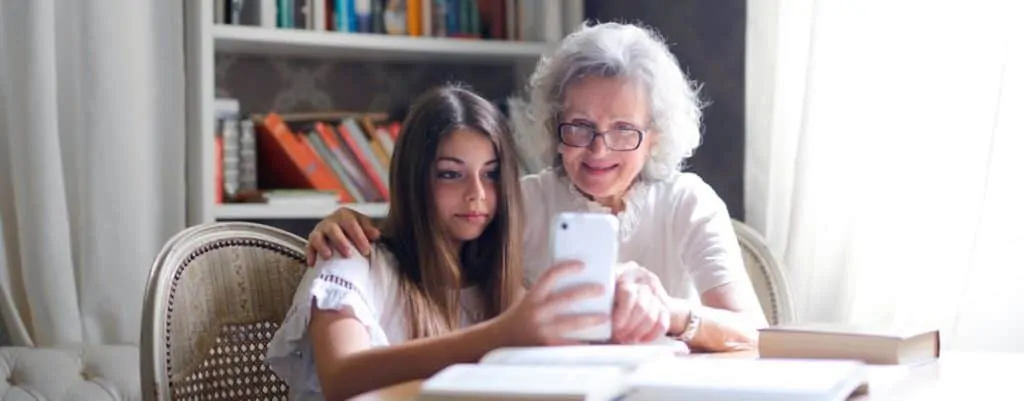Grandma reading phone with granddaughter