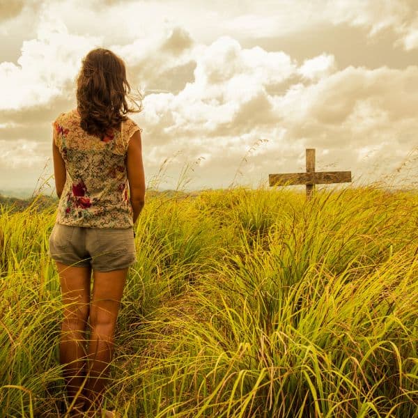 Daughter viewing mothers grave from a distance